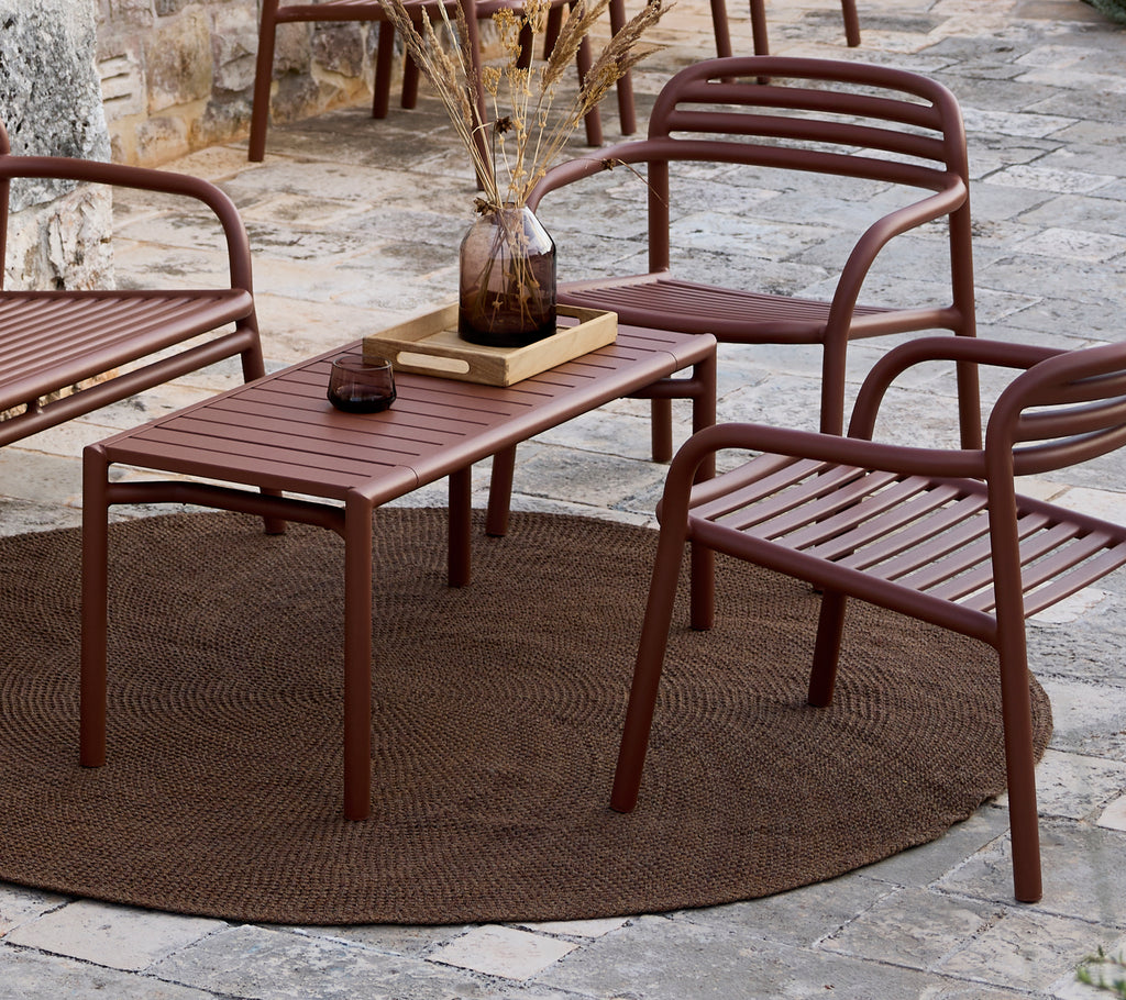 Table et chaises brunes minimalistes disposées dans un cadre de salon.