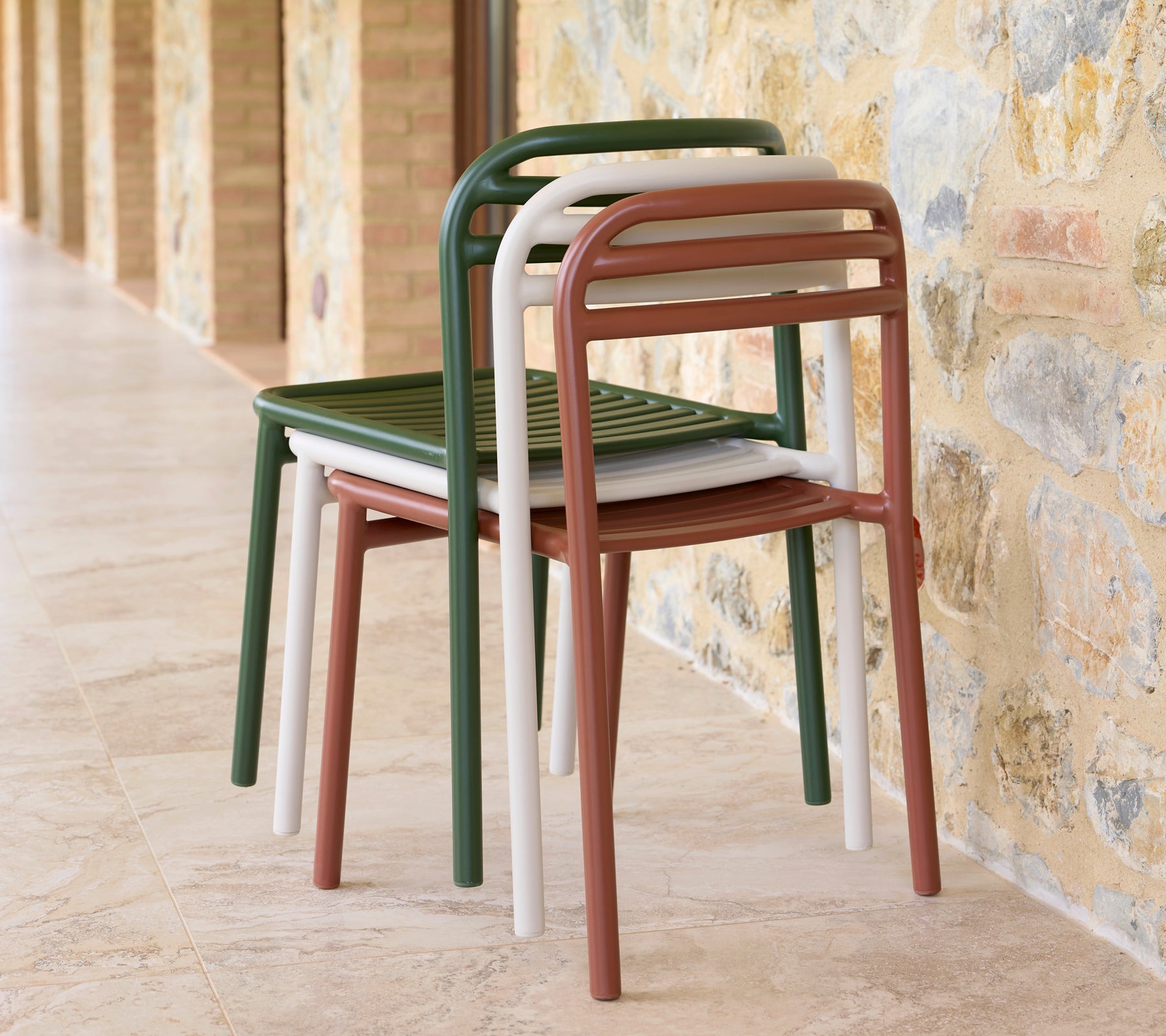 Une pile de chaises Bliss de différentes couleurs, mettant en avant un design épuré et une praticité pour un rangement gain de place.