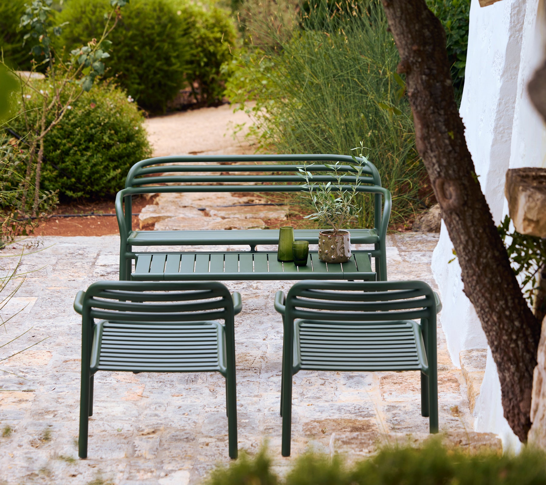 Banc et chaises modernes verts dans un cadre de salon extérieur élégant.