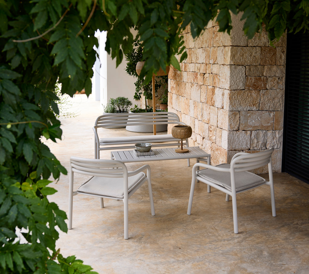 Canapé gr grey et fauteuil avec une table blanche dans un cadre de salon moderne.