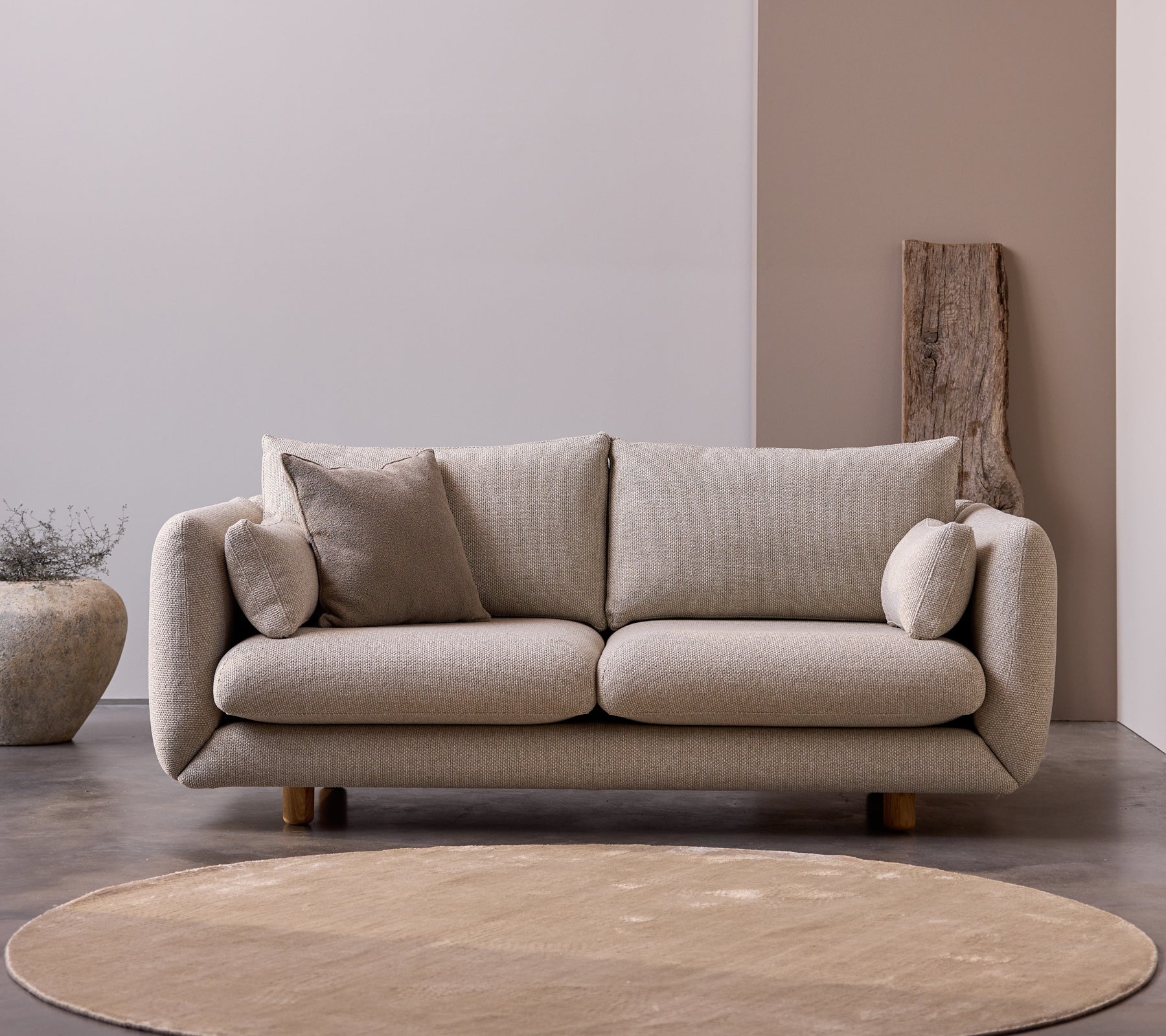 Canapé 2 places Bloom avec des pieds en teck dans la couleur Desert Sand, comportant des coussins moelleux et un design doux et minimaliste.