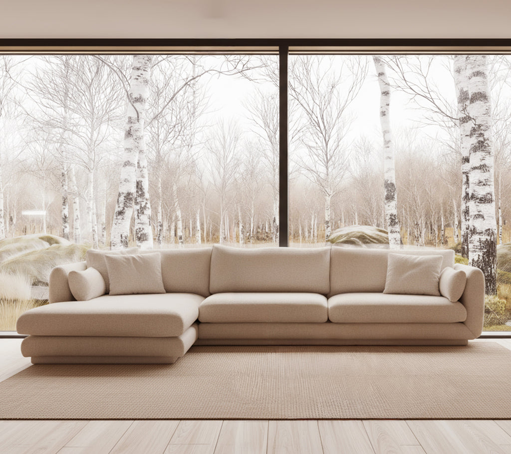 Canapé moderne beige dans un environnement de salon lumineux avec de grandes fenêtres.