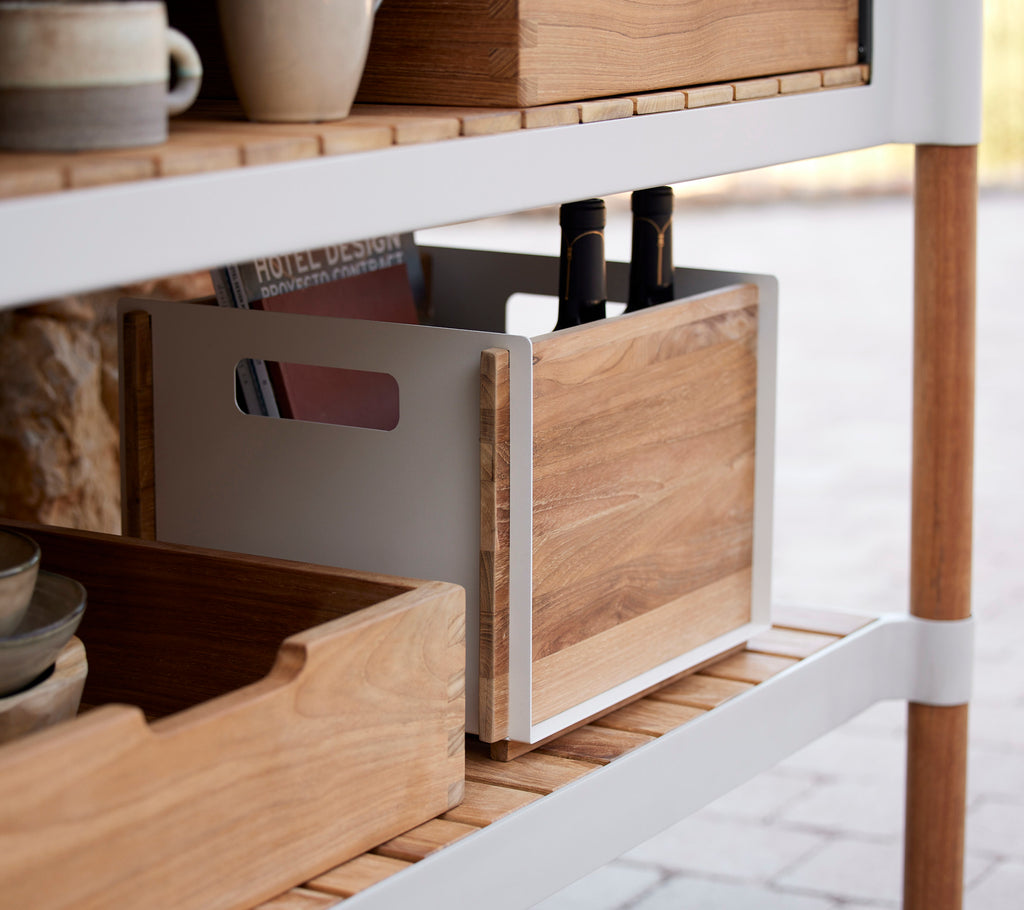 Boîtes de rangement en bois sur une étagère, l'une contenant des ustensiles de cuisine, avec un design minimaliste et des finitions naturelles.