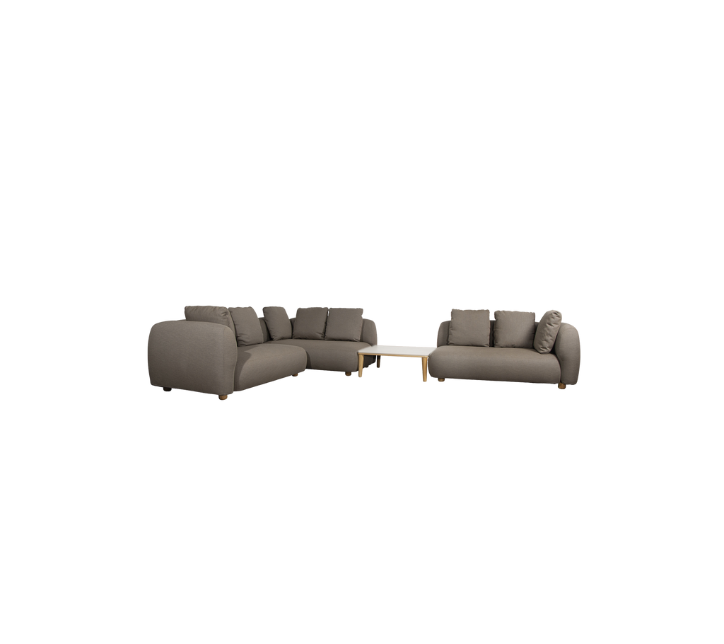 Canapé taupe moderne avec des coussins et une table claire dans un cadre de salon.