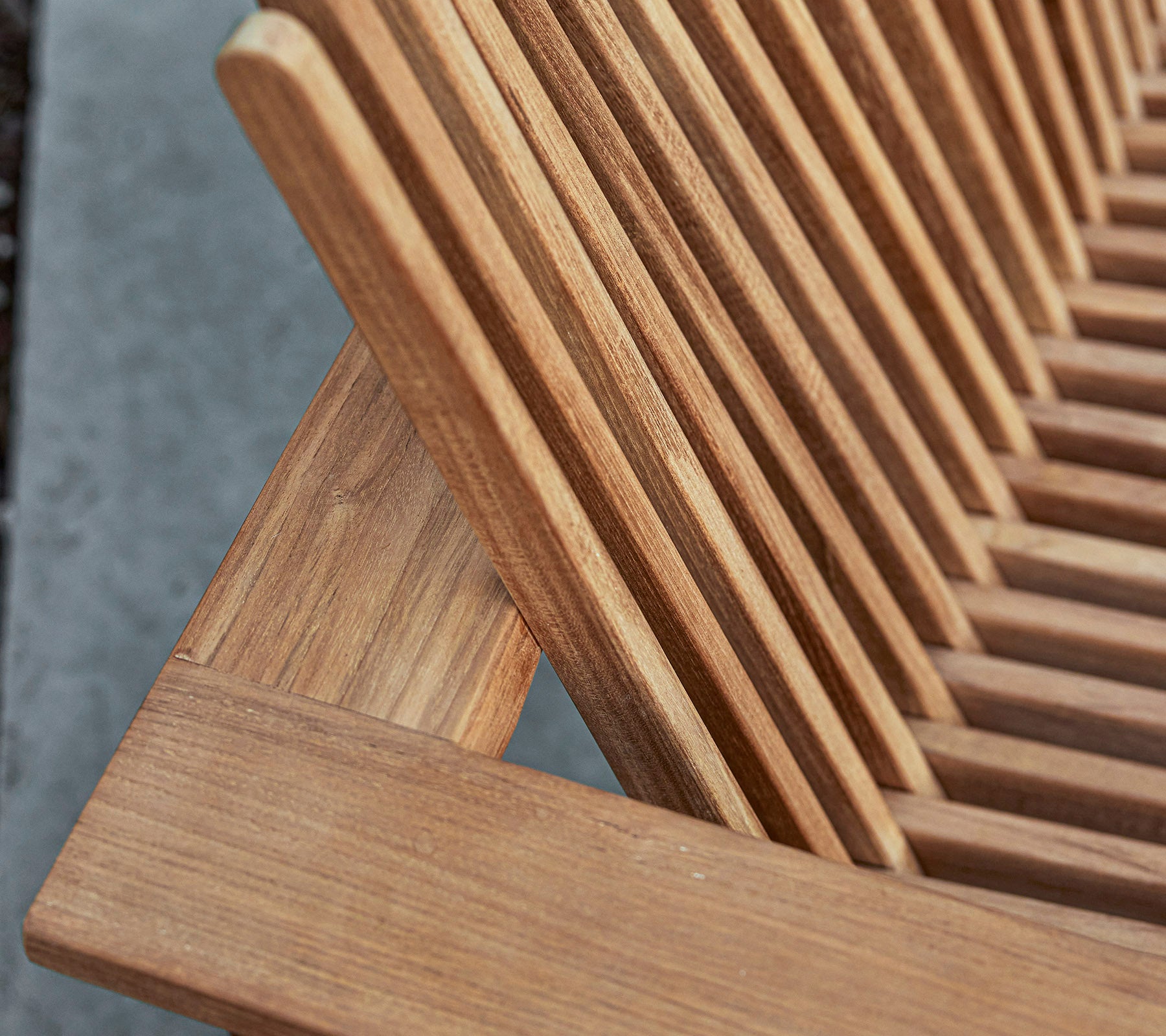 Gros plan d'un meuble en bois avec un design à lattes, mettant en valeur le grain naturel et les détails de l'artisanat.