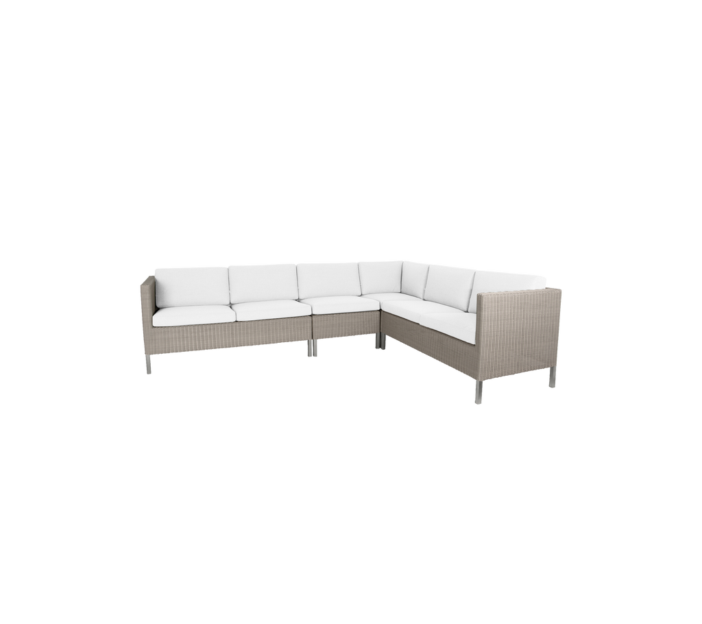 Canapé d'angle d'extérieur élégant avec des coussins blancs moelleux et un design en osier moderne, parfait pour des rassemblements et la détente.