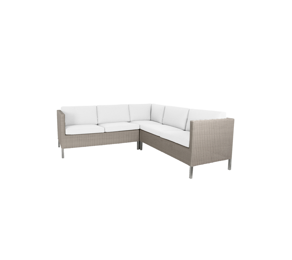 Coin salon élégant avec un coussin de couleur claire et un extérieur tissé, parfait pour des rassemblements décontractés.