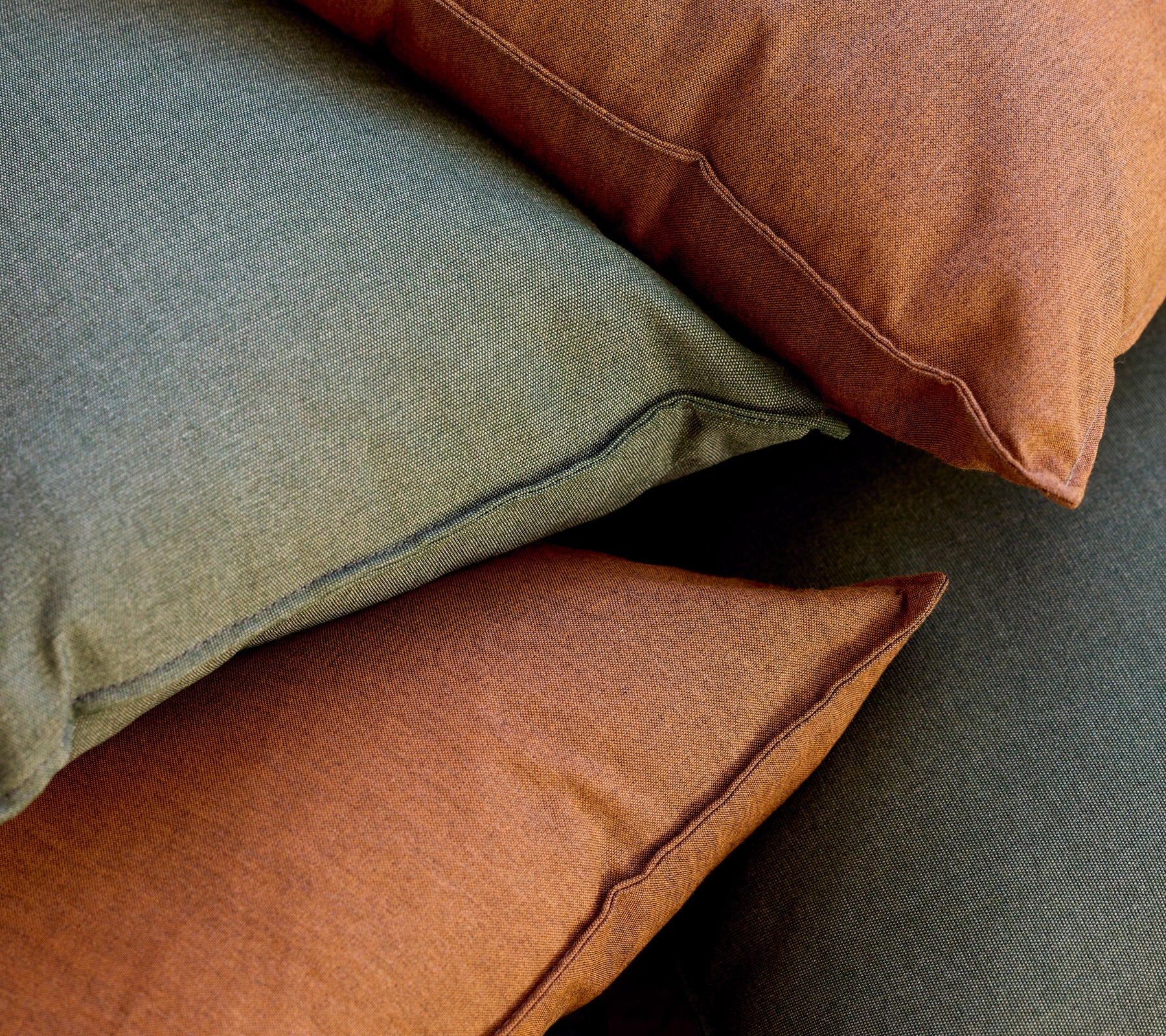 Tas de coussins verts et bruns disposés ensemble.