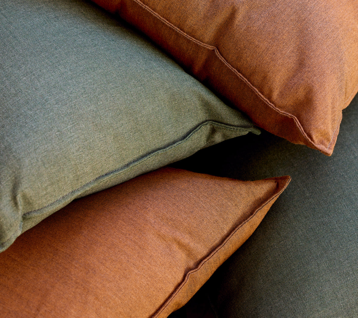 Tas de coussins verts et bruns disposés ensemble.