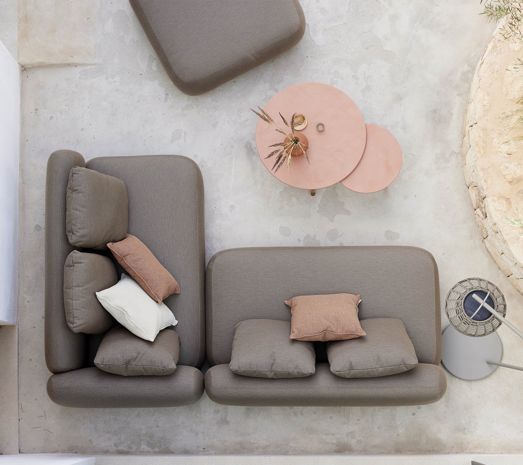 Un aménagement de sièges élégant avec un canapé de couleur neutre orné de coussins décoratifs, accompagné d'une table basse twist unique.