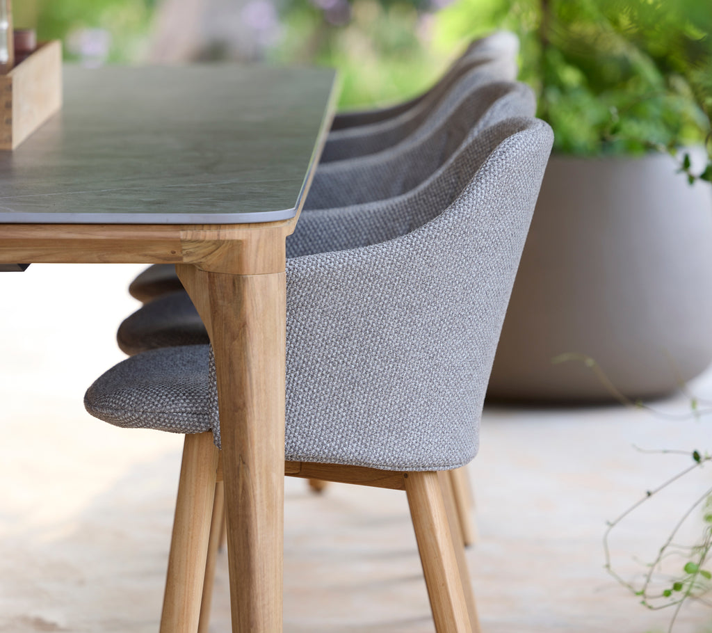 Chaise et table grises modernes dans un cadre extérieur serein.