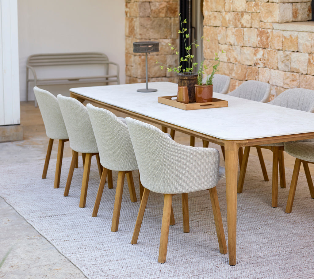 Aménagement moderne de salle à manger avec une table blanche et des chaises beige.