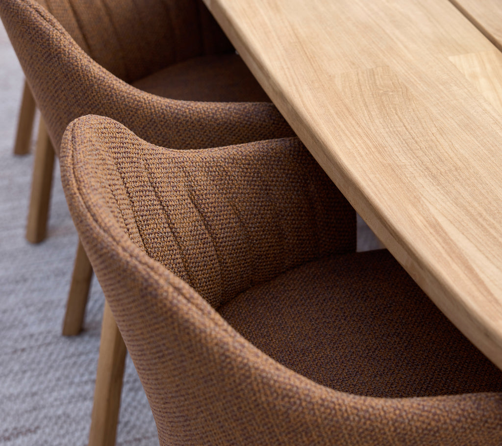 Chaises de salle à manger marron associées à une table en bois dans un cadre moderne.