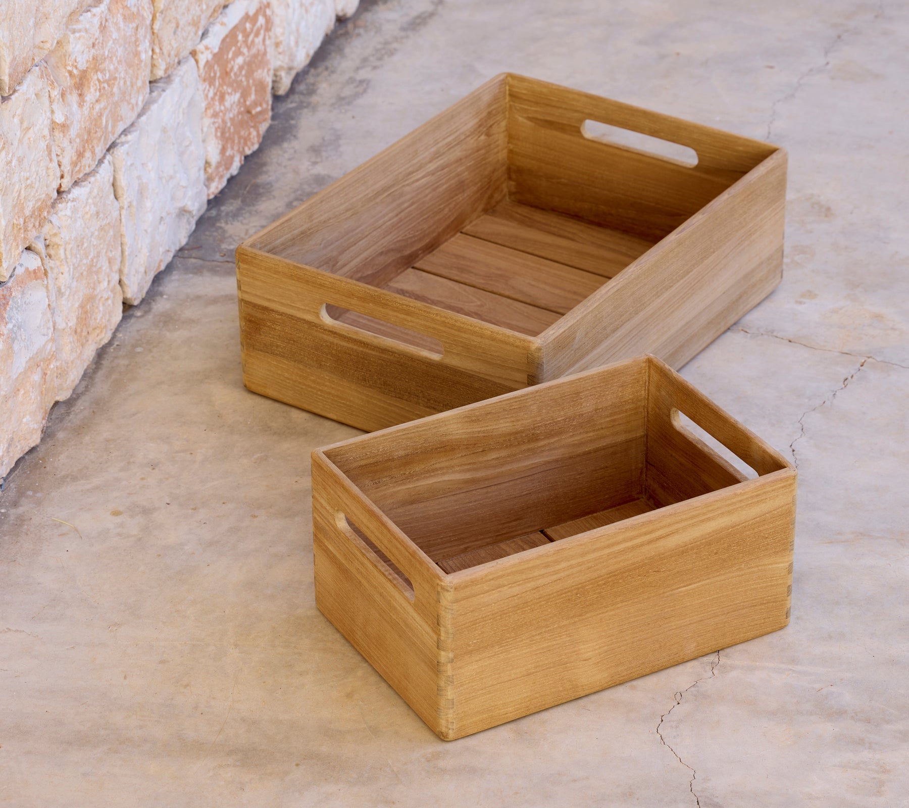 Deux caisses en bois de tailles différentes placées sur une surface en béton.