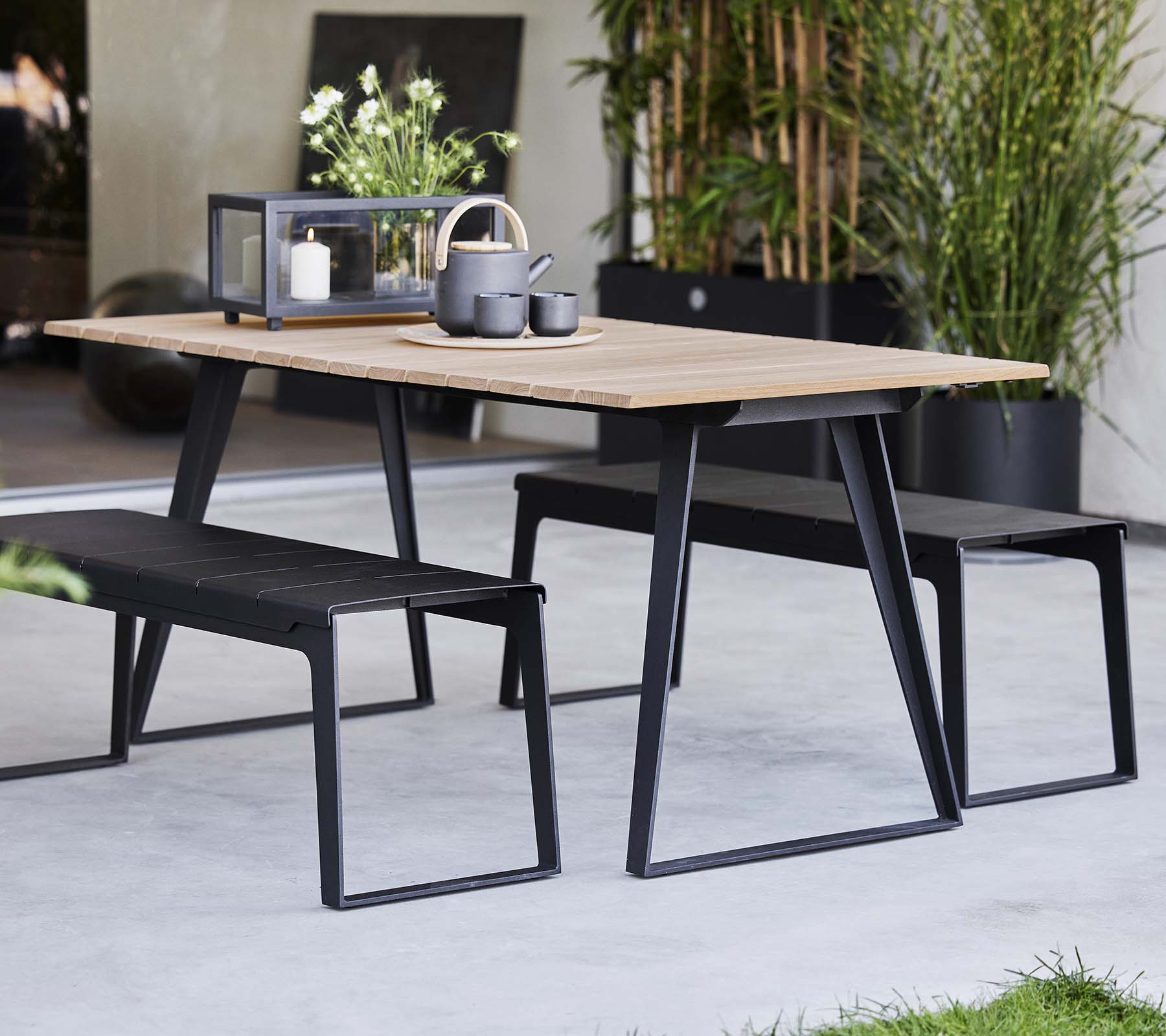 Table élégante de Copenhague agrémentée de bancs assortis, présentant un design moderne et des éléments de décoration minimalistes.