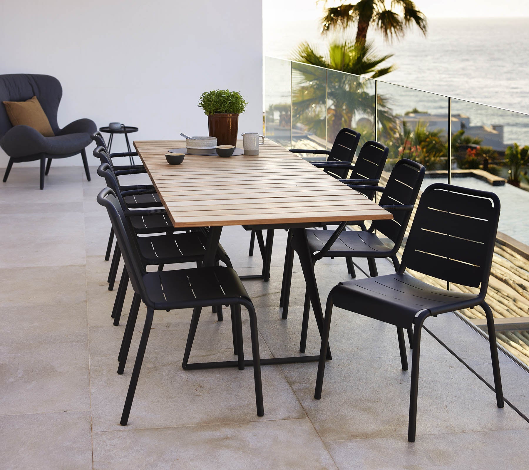 Une table de Copenhague avec un plateau en bois entourée de chaises noires de Copenhague, créant une installation de salle à manger élégante.