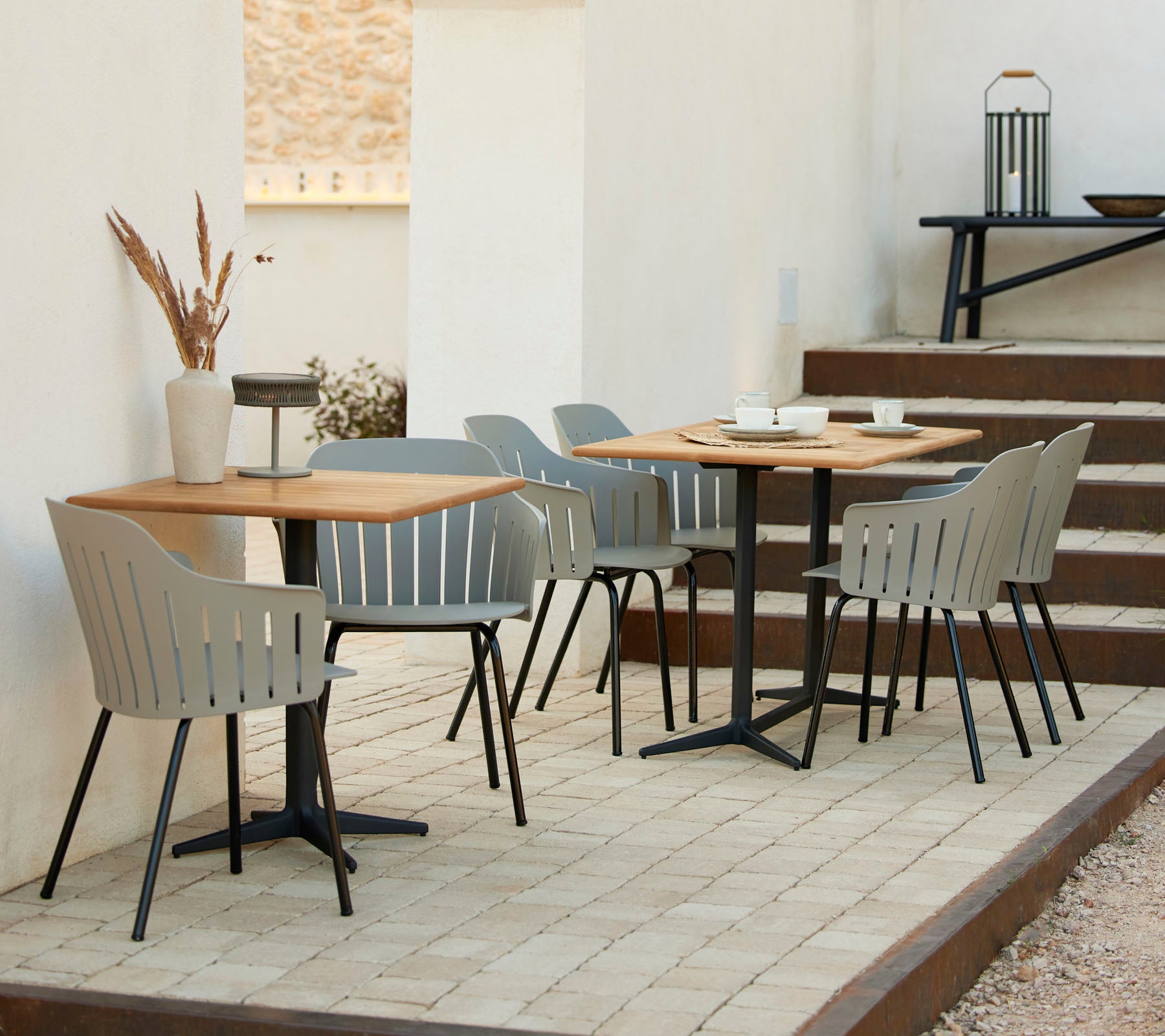 Un cadre de café élégant avec des tables en bois, des chaises grises et des accents décoratifs, idéal pour des rassemblements décontractés et la détente.