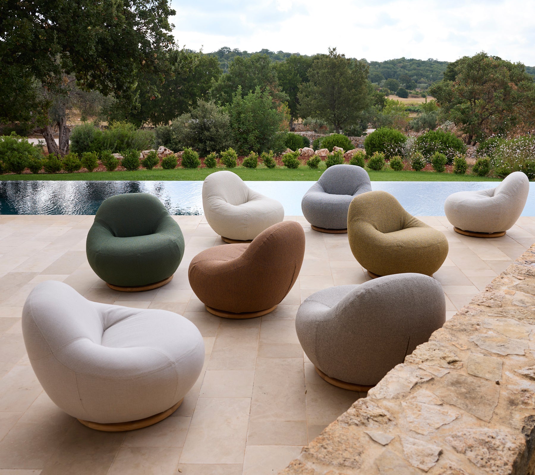 Ensemble de chaises modernes de différentes couleurs disposées autour d'une piscine.
