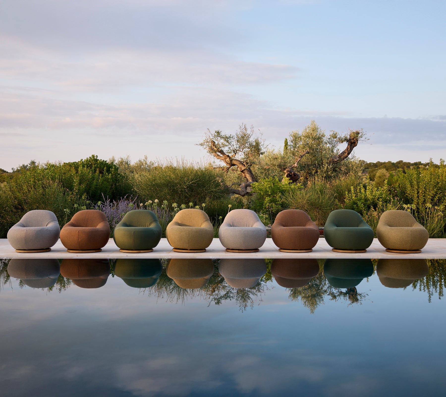 Chaises d'extérieur contemporaines de différentes couleurs disposées au bord de la piscine.