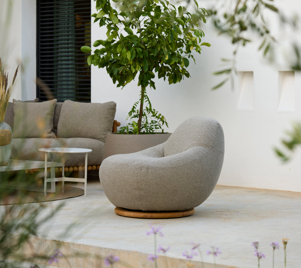 Cadre moderne de salon avec une chaise grise, un coussin gris et une table blanche.