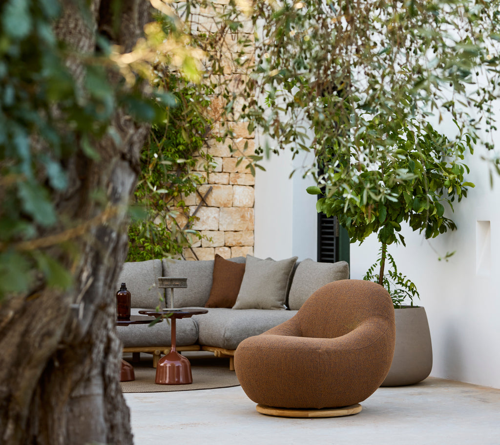 Espace salon moderne avec une chaise brune et un canapé gris.