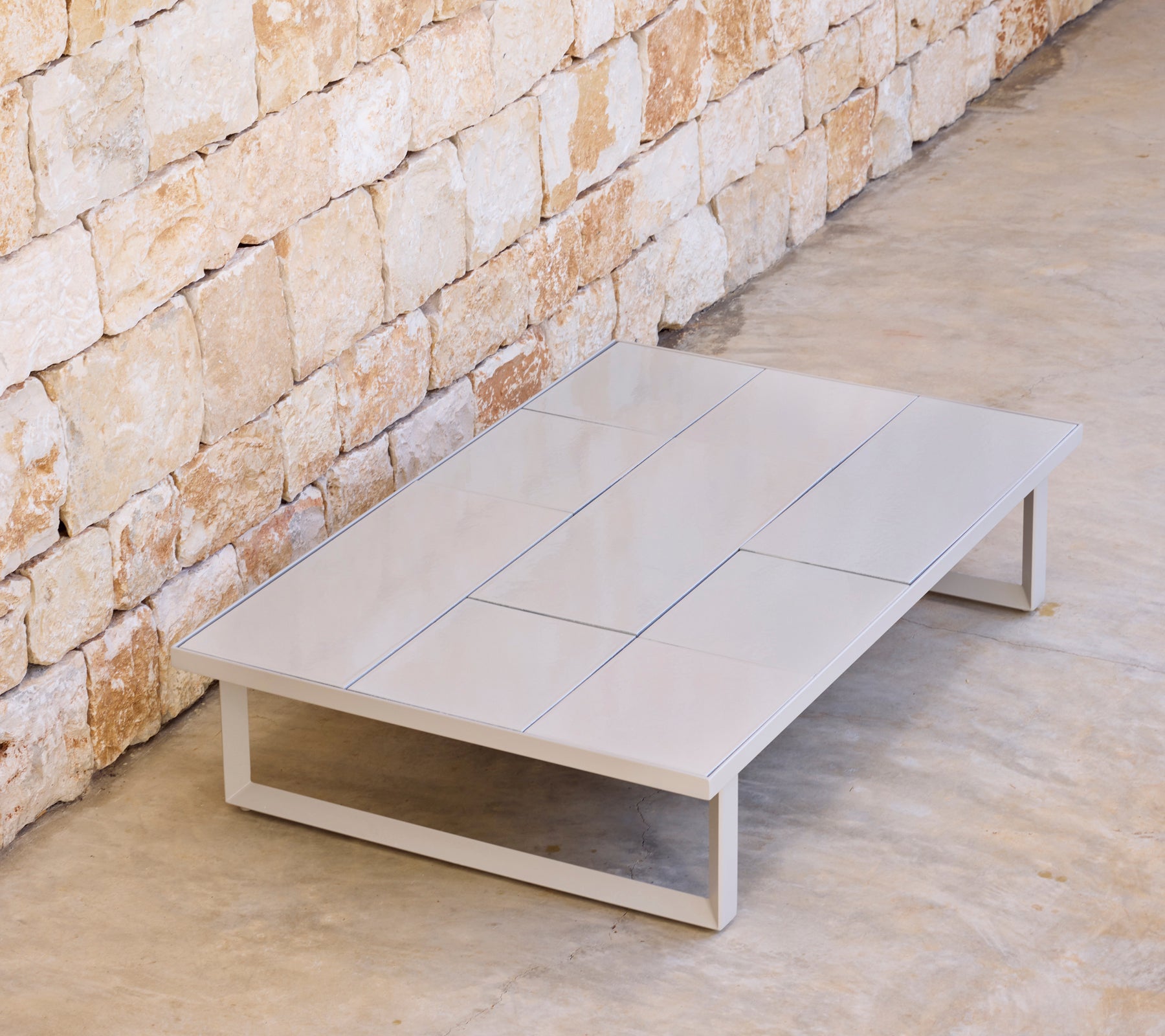 Table basse moderne grise au design minimaliste dans un cadre naturel.