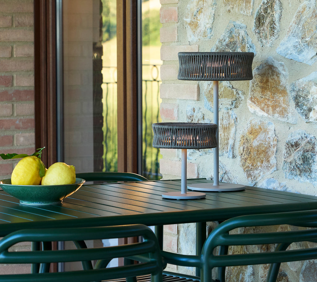 Petites et moyennes lampes d'illusion sur une table avec un bol de citrons, entourées d'éléments en pierre et en verre.