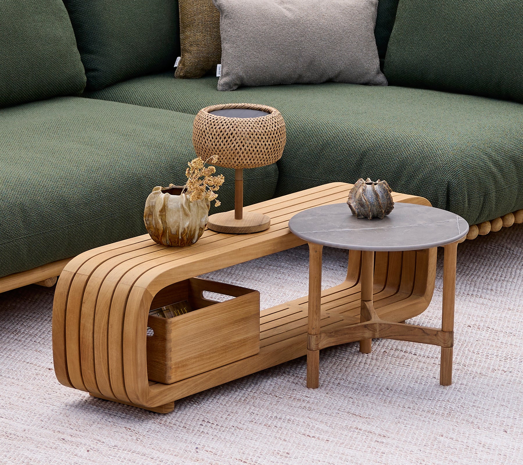 Table basse en bois moderne avec une table d'appoint grise, une lampe et un vase décoratif dans un cadre de salon.