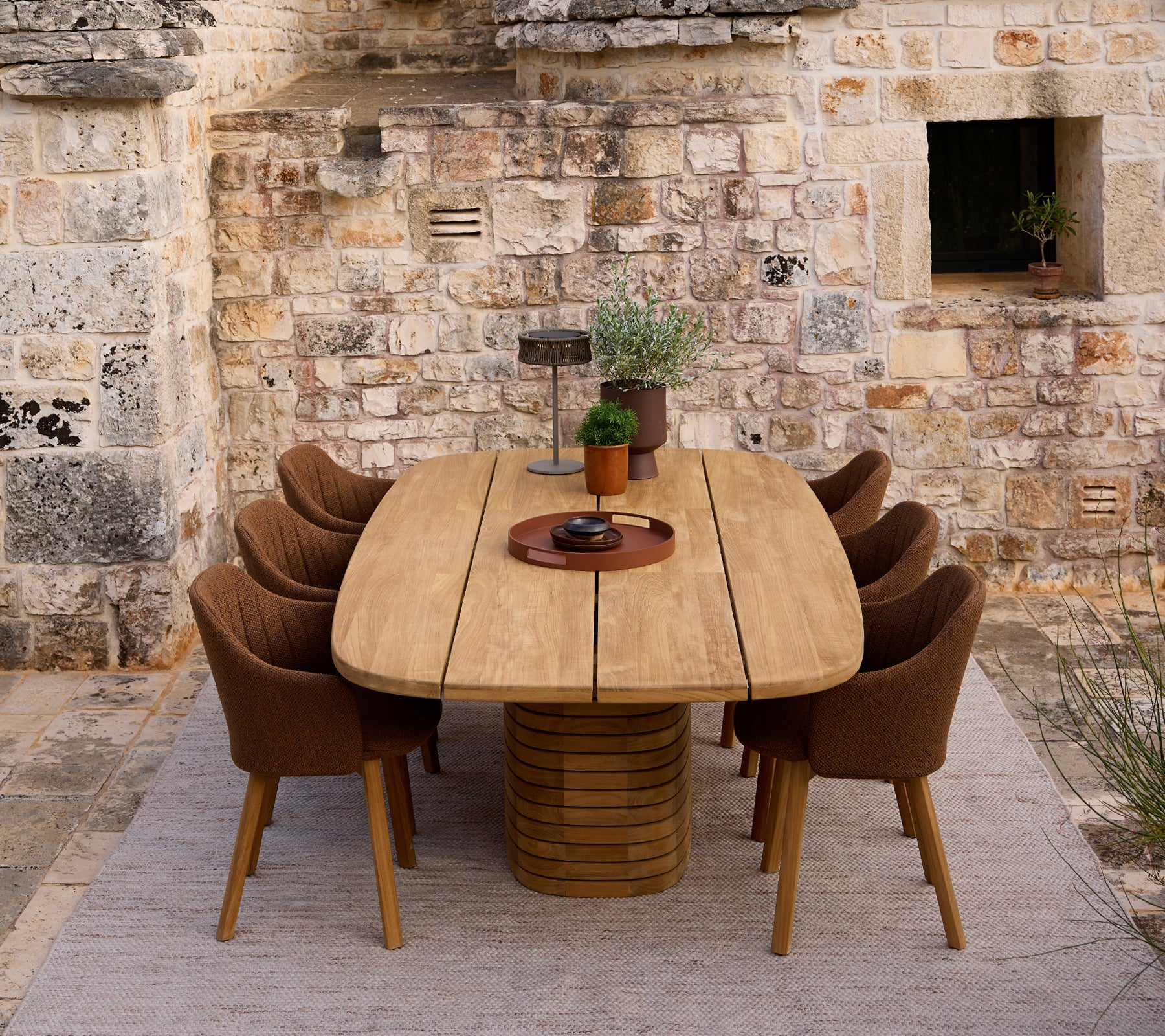 Table à manger en bois moderne entourée de chaises brunes dans un cadre rustique.
