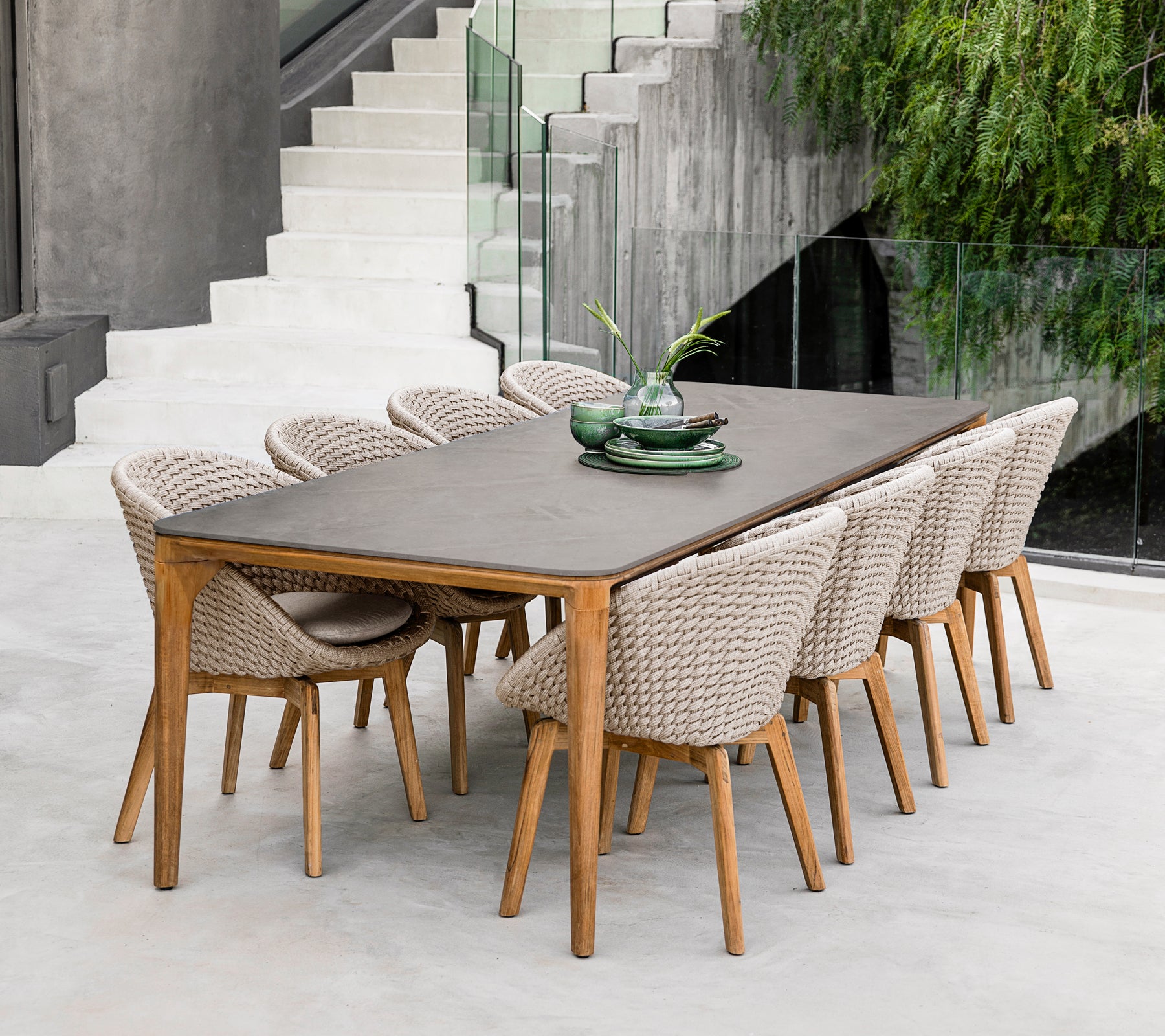 Table à manger moderne en bois brun avec des chaises tressées dans un cadre contemporain.