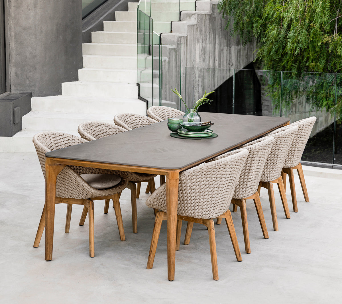 Table à manger moderne en bois brun avec des chaises tressées dans un cadre contemporain.