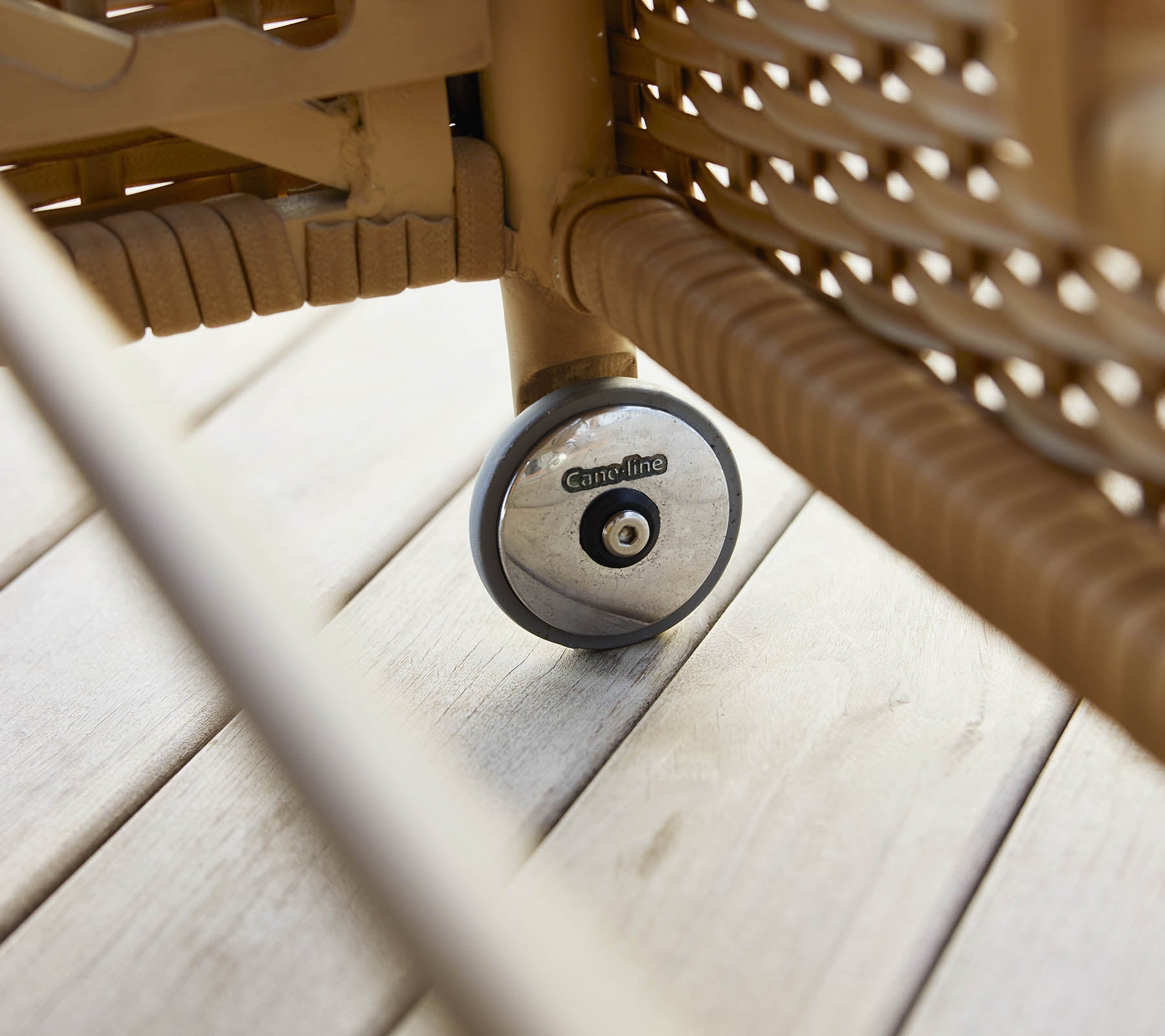 Un gros plan de la roue d'un transat, mettant en valeur son design et sa texture sur une surface en bois.