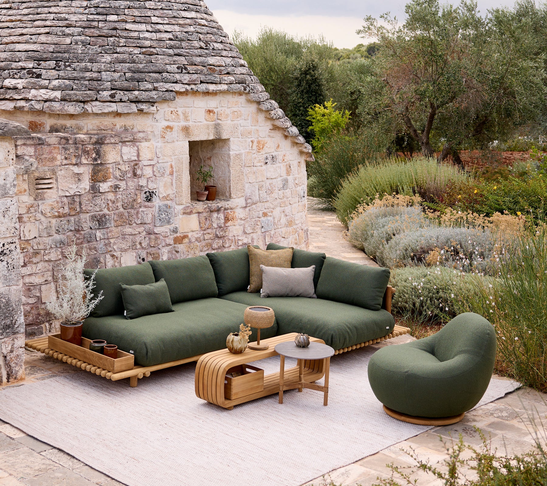 Canapé et chaise verts modernes avec une table brune dans un cadre de jardin.