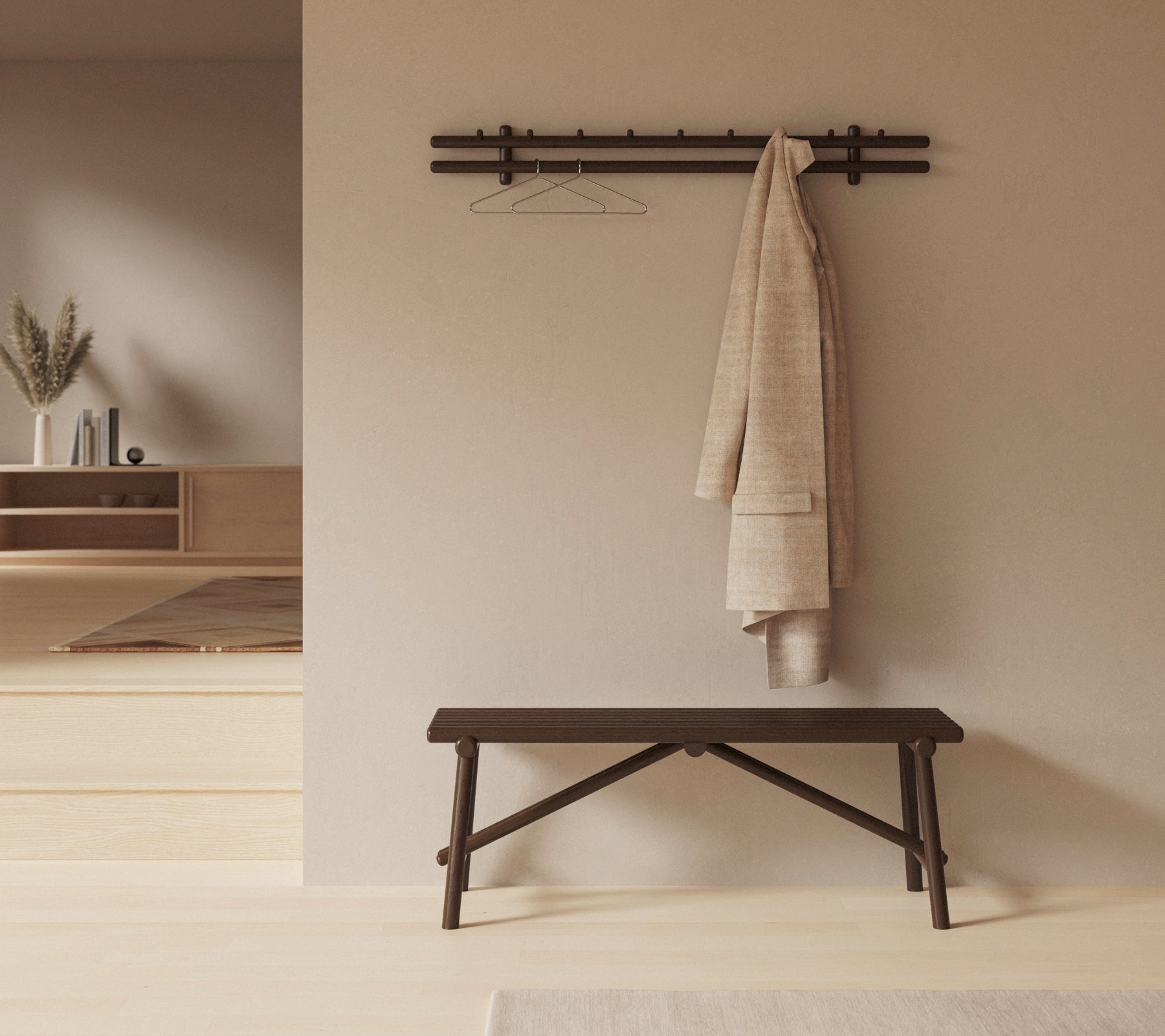 Un banc en bois sombre avec un grand chiffon drapé dessus, et un support mural avec un cintre, placé sur un fond neutre.