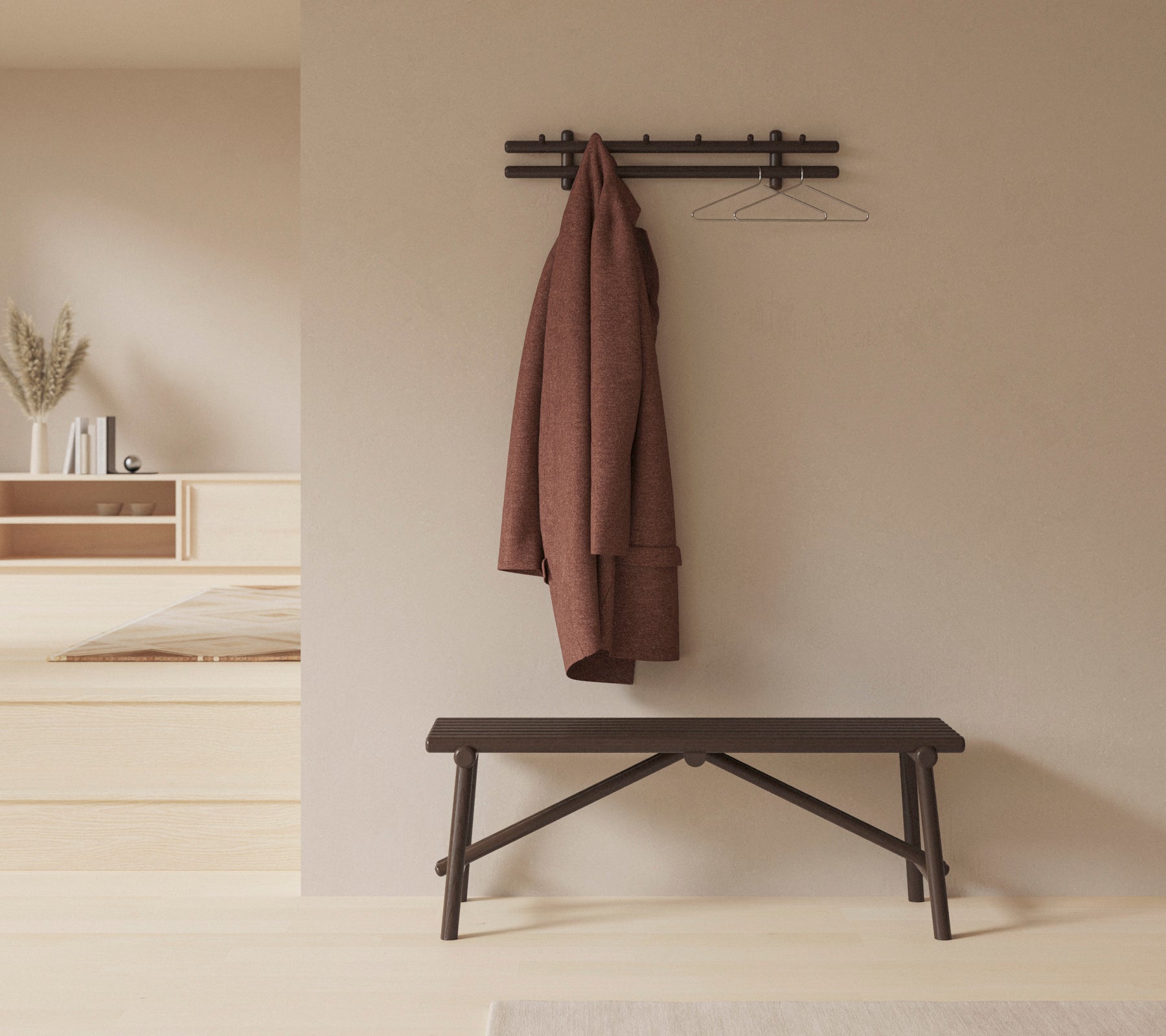 Un cadre minimaliste avec un banc en bois et un manteau accroché à un porte-manteau mural, renforçant la simplicité et la fonctionnalité de l'espace.