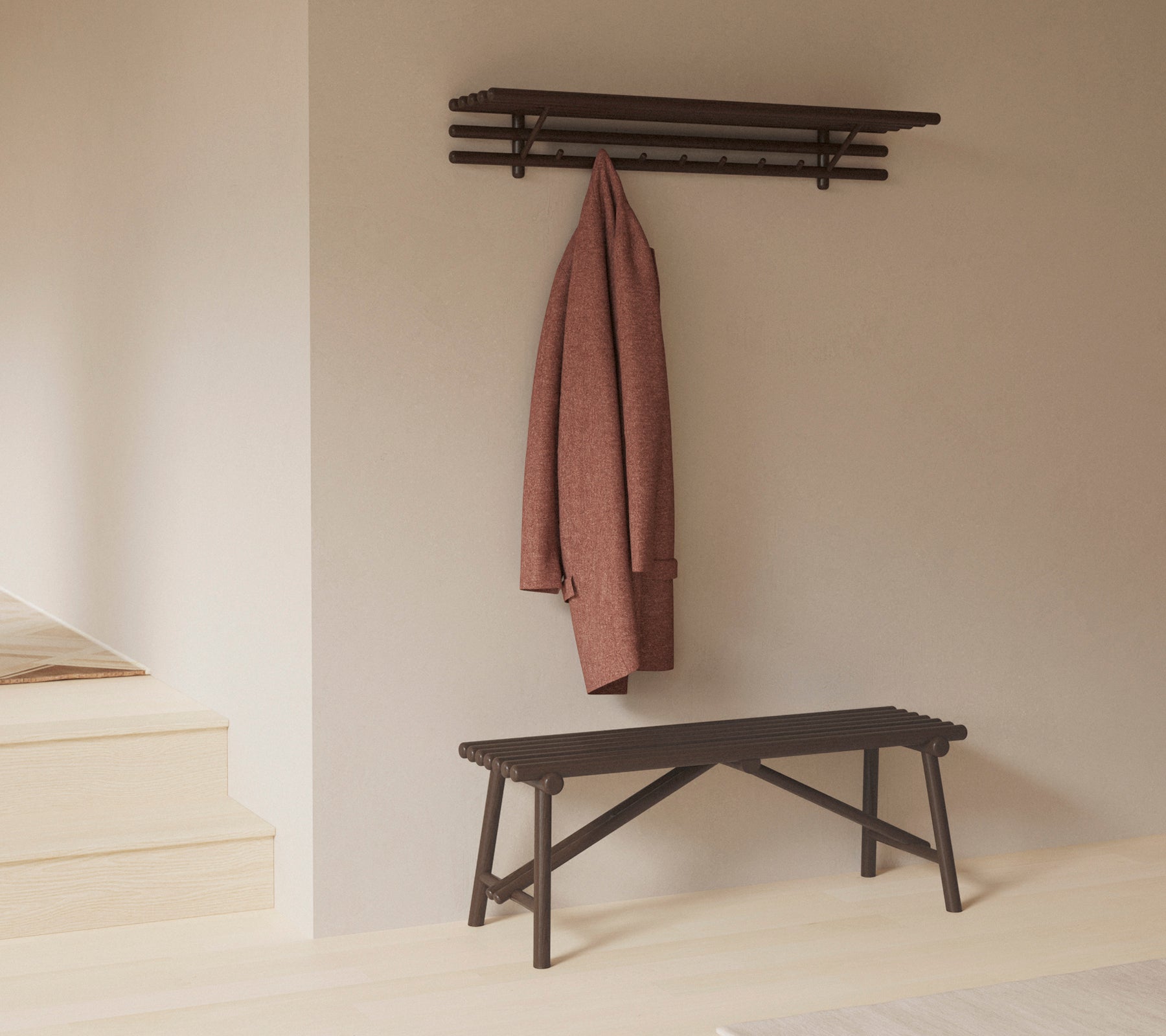 Un banc minimaliste avec une étagère au-dessus, mettant en avant un manteau suspendu à des crochets, soulignant la simplicité et la fonctionnalité dans le design.