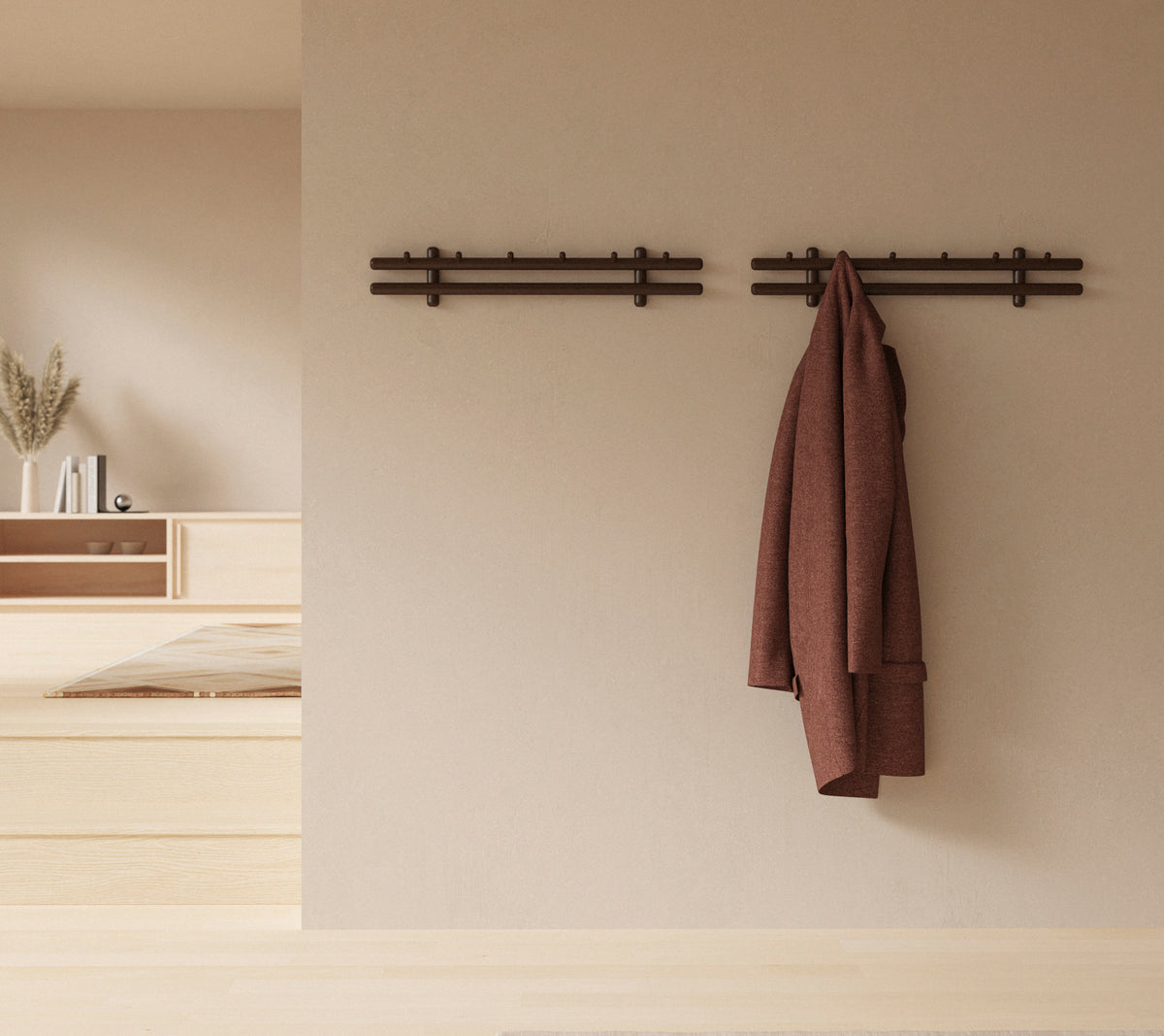 Un affichage mural minimaliste avec des bâtons en bois tenant un manteau et un ensemble de chiffons, améliorant l'esthétique du décor rustique.