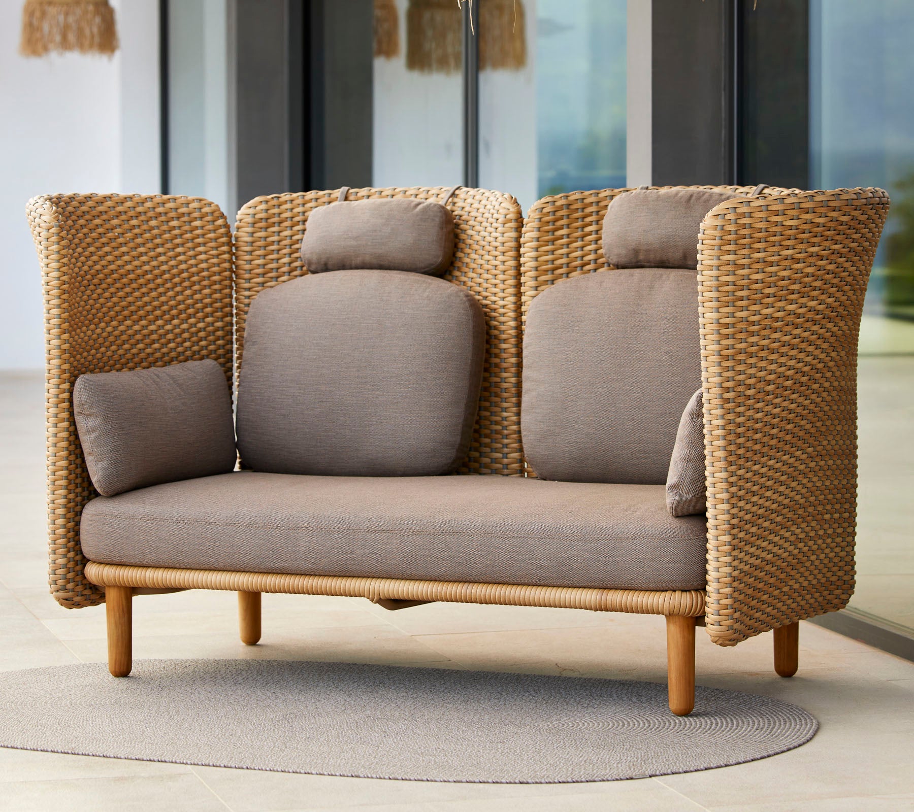 Canapé deux places élégant avec texture tissée, doté de coussins confortables et d'une base en bois naturel, idéal pour la détente.