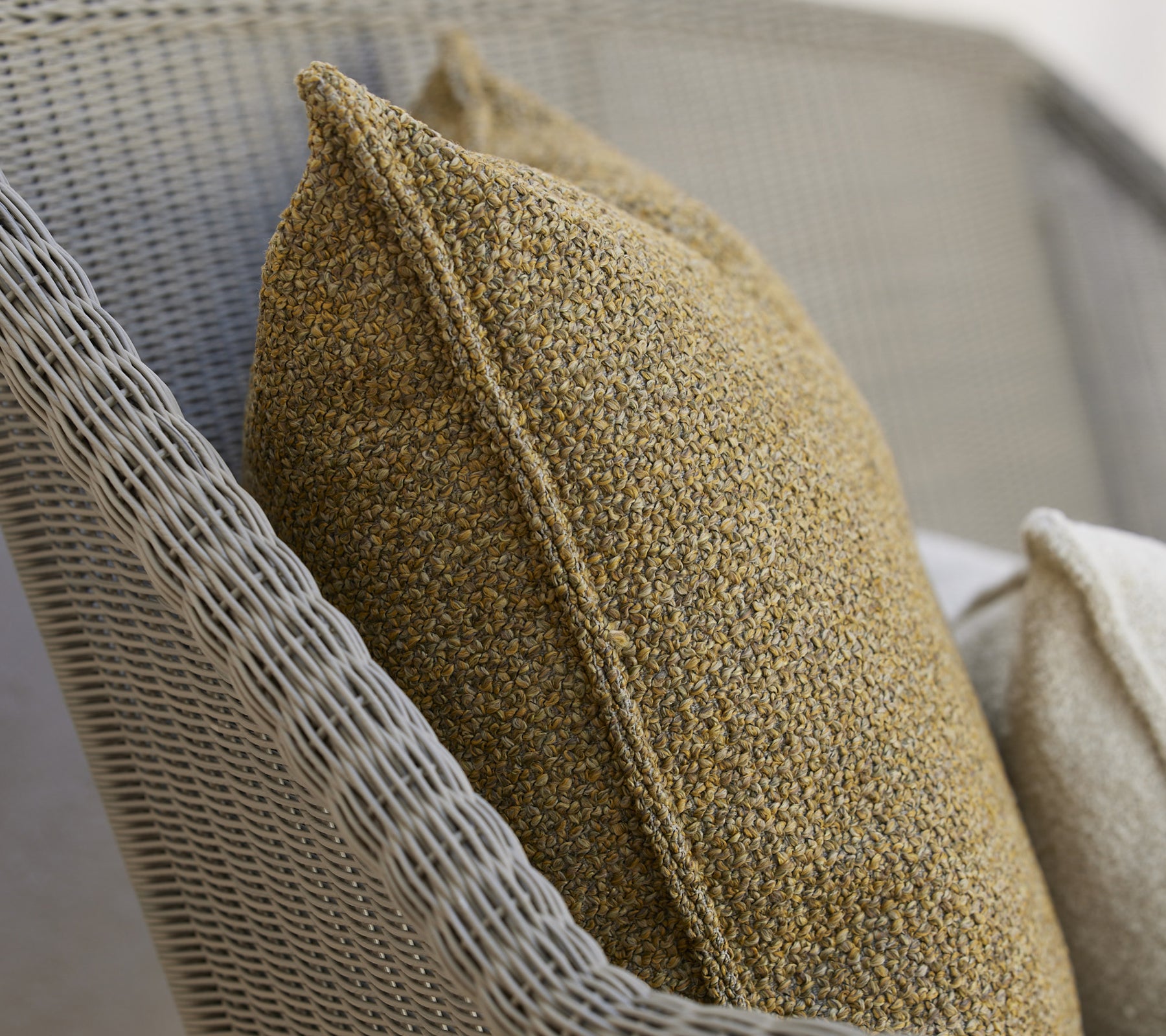 Des coussins texturés dans des tons chauds sur une surface tissée, offrant une touche cosy et élégante pour la détente.